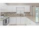 Modern kitchen with white cabinets, stainless steel appliances, granite counters, and a stylish tile backsplash at 503 20Th Ave. N # 15B, North Myrtle Beach, SC 29582