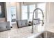 Modern kitchen features a stainless steel faucet, granite counters, and a breakfast bar with gray upholstered chairs at 5039 Selene Ct., Myrtle Beach, SC 29588