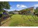Spacious backyard with lush lawn, playground equipment, and a charming pergola covered patio for outdoor entertaining at 5149 Morning Frost Pl., Myrtle Beach, SC 29579