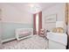 Cozy Bedroom featuring soft pink walls, elegant draperies, and a comfortable crib at 5149 Morning Frost Pl., Myrtle Beach, SC 29579