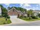 Beautifully landscaped front yard of a brick home, featuring a lush lawn and mature plantings at 5149 Morning Frost Pl., Myrtle Beach, SC 29579