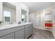 A bright bathroom with a double sink vanity, a large mirror, wood plank flooring, and a shower with a curtain at 555 Strawberry Field Way, Galivants Ferry, SC 29544