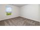 This bedroom is bright and airy with carpeted floors and a view of a green space from the window at 555 Strawberry Field Way, Galivants Ferry, SC 29544
