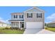 Charming two-story home with grey and blue siding, black shutters, and an attached two-car garage at 555 Strawberry Field Way, Galivants Ferry, SC 29544