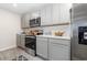Well-lit kitchen features stainless steel appliances, grey cabinets, and light countertops at 555 Strawberry Field Way, Galivants Ferry, SC 29544