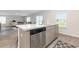 Kitchen island with stainless steel dishwasher and gray cabinets overlooking an open-concept living space at 555 Strawberry Field Way, Galivants Ferry, SC 29544