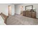 A neatly furnished main bedroom with neutral carpet, a dressing table and views to the ensuite bathroom and walk-in closet at 555 Strawberry Field Way, Galivants Ferry, SC 29544