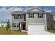 Charming two-story home with gray siding, blue shutters, well-manicured lawn, and a two car garage at 579 Strawberry Field Way, Galivants Ferry, SC 29544