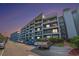 Multi-story condominium complex with parking area and balconies on each level offering outdoor living space at 5905 South Kings Hwy. # 132B, Myrtle Beach, SC 29575