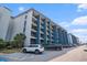 Multi-story condominium complex with parking area and balconies, featuring a striking blue and gray color scheme at 5905 South Kings Hwy. # 132B, Myrtle Beach, SC 29575