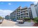 Multi-story condominium complex with parking area and balconies on each level offering outdoor living space at 5905 South Kings Hwy. # 132B, Myrtle Beach, SC 29575
