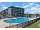 Large outdoor pool area with ample lounge chairs and views of the surrounding building and landscaping at 5905 South Kings Hwy. # 132B, Myrtle Beach, SC 29575