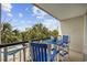 Balcony with a table and chairs overlooks a pool and palm trees at 601 Retreat Beach Circle # 213, Pawleys Island, SC 29585