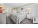 Charming bedroom with coastal decor, a comfortable queen-sized bed, and a wood paneled accent wall at 601 Retreat Beach Circle # 213, Pawleys Island, SC 29585