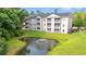 Apartment building view showcases a serene pond with a fountain at 6016 Dick Pond Rd. # 109, Myrtle Beach, SC 29588