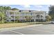 Low-angle view of a three-story condo building with stairs, walkways, and palm trees on a sunny day at 6253 Catalina Dr. # 534, North Myrtle Beach, SC 29582