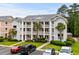 Three-story condo building featuring multiple balconies, green landscaping, and ample parking at 639 Waterway Village Blvd # 14-I, Myrtle Beach, SC 29579