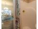 Bright bathroom featuring a shower with gold fixtures and a patterned shower curtain next to an adjacent dining area at 690 Riverwalk Dr. # 201, Myrtle Beach, SC 29579