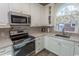 Bright kitchen featuring white cabinets, modern appliances, granite countertops, and tiled backsplash at 690 Riverwalk Dr. # 201, Myrtle Beach, SC 29579