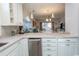 Open kitchen with white cabinets, stainless steel appliances, and views into the dining and living areas at 690 Riverwalk Dr. # 201, Myrtle Beach, SC 29579