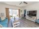 Bright living room featuring hardwood floors and sliding glass doors to a private patio at 690 Riverwalk Dr. # 201, Myrtle Beach, SC 29579