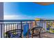 Stunning balcony view of the ocean and coastline with patio furniture and incredible blue skies at 7100 N Ocean Blvd. # 1421, Myrtle Beach, SC 29572