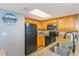 Modern kitchen with wood cabinetry, black appliances, and granite countertops for a stylish look at 7100 N Ocean Blvd. # 1421, Myrtle Beach, SC 29572