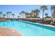 Large outdoor pool surrounded by palm trees and rows of lounge chairs for relaxing at 7100 N Ocean Blvd. # 1421, Myrtle Beach, SC 29572