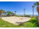 Outdoor beach volleyball court surrounded by grass, shrubs, and palm trees at 7100 N Ocean Blvd. # 1421, Myrtle Beach, SC 29572