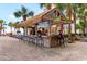 Outdoor tiki bar by the pool with stools and tropical decor surrounded by palm trees at 7200 N Ocean Blvd. # 553, Myrtle Beach, SC 29572