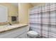 Well-lit bathroom with granite counters and striped shower curtain at 788 Gabreski Ln. # B4, Myrtle Beach, SC 29577