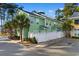 Rear exterior view of colorful townhomes with white fences, mature trees, and a private walkway at 788 Gabreski Ln. # B4, Myrtle Beach, SC 29577