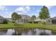 Backyard view shows a waterfront lot, screened porch, well-maintained lawn, and mature landscaping at 837 Sand Binder Dr., Myrtle Beach, SC 29579
