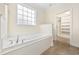 Bright bathroom features a soaking tub, tile floors, natural light, and a walk in closet at 837 Sand Binder Dr., Myrtle Beach, SC 29579