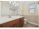 Well-lit bathroom featuring a wood vanity, large mirror, and shower/tub combination at 837 Sand Binder Dr., Myrtle Beach, SC 29579