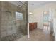 Bright bathroom boasts a tiled glass shower, natural light, a vanity with sink and access to the Primary bedroom at 837 Sand Binder Dr., Myrtle Beach, SC 29579