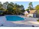 Community pool featuring a bath house and surrounded by mature trees at 9724 Indigo Creek Blvd., Murrells Inlet, SC 29576