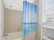Neutral-tiled bathroom with a blue shower curtain and chrome showerhead at 104 East Bay St., Georgetown, SC 29440