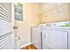 A functional laundry room with a washer, dryer, overhead shelving, and wood-look floors at 109 Butkus Dr. # 2-1, Myrtle Beach, SC 29588