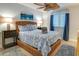 Bedroom with a wicker bed frame, blue bedding, neutral walls, and a ceiling fan at 1212 Ocean Blvd. S # 202, Surfside Beach, SC 29575