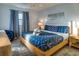 Bright bedroom with wooden floors, blue bedding, a window, and contemporary decor at 1212 Ocean Blvd. S # 202, Surfside Beach, SC 29575