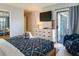 Relaxing bedroom featuring a nautical-themed bedspread, flatscreen TV, and private access to the outdoor deck at 1212 Ocean Blvd. S # 202, Surfside Beach, SC 29575