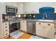 Modern kitchen featuring stainless steel appliances, blue tiled backsplash, and white cabinets at 1212 Ocean Blvd. S # 202, Surfside Beach, SC 29575