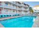 Refreshing in-ground pool surrounded by lounge chairs and well-maintained landscaping near the residence at 1212 Ocean Blvd. S # 202, Surfside Beach, SC 29575
