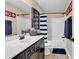 Bathroom featuring a vanity with black cabinets, a mirror, and a bathtub with a striped shower curtain at 1227 Cypress Shadow Ct., Murrells Inlet, SC 29576