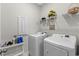 Practical laundry room with modern washer and dryer, storage shelving, and utility supplies at 1331 Winding Creek Way, Myrtle Beach, SC 29588