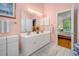 Pink-themed bathroom featuring double sinks, lots of light, and neutral tile floor at 168 Mackinley Circle, Pawleys Island, SC 29585