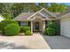 Charming front entrance with brick accents, decorative door wreath, and well-maintained landscaping at 168 Mackinley Circle, Pawleys Island, SC 29585