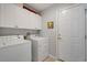 Functional laundry room with a washer, dryer, storage cabinets, and exterior door at 168 Mackinley Circle, Pawleys Island, SC 29585