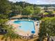 Aerial view of a community pool, surrounded by lounge chairs and blue umbrellas for relaxation at 168 Mackinley Circle, Pawleys Island, SC 29585